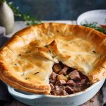 Lancashire sliced meat and potato pie with flaky pie crust lid on top.