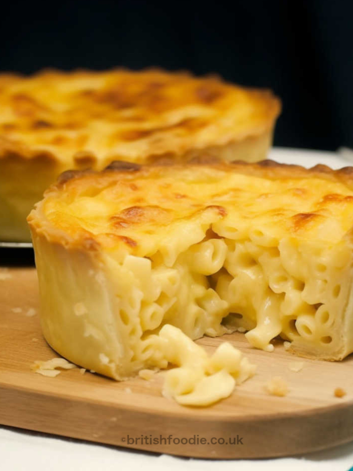 Golden-baked macaroni and cheese pies cooling on a rack after coming out of the oven