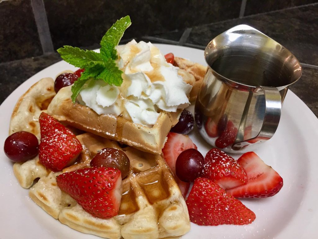 belgian waffle with syrup, strawberries and cream