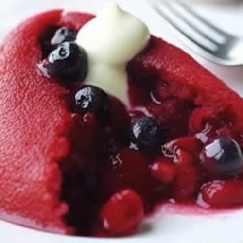 slice of blackcurrant summer pudding with strawberries, redcurrants and cherries