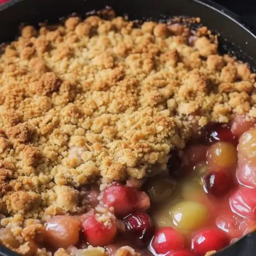 Crumble with red rhubarb sauce spread over tart green gooseberries.