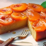 A perfect upside-down apricot and ginger cake on a plate, moist ginger sponge topped with caramelized glossy apricot halves on a ceramic plate