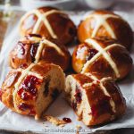 Hot Cross Buns with a spread of strawberry jam
